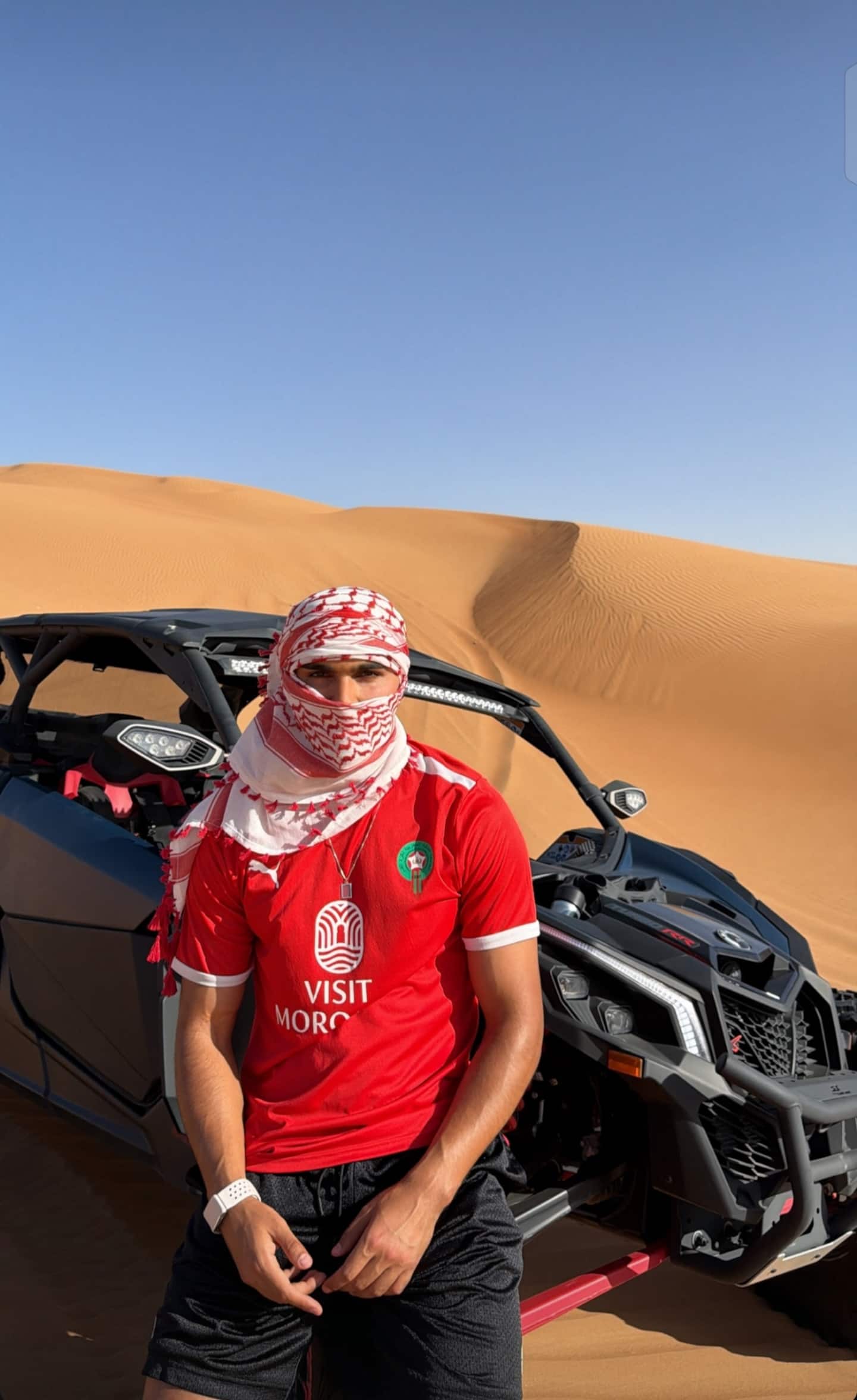 Local guide standing in front of a two-seat desert buggy