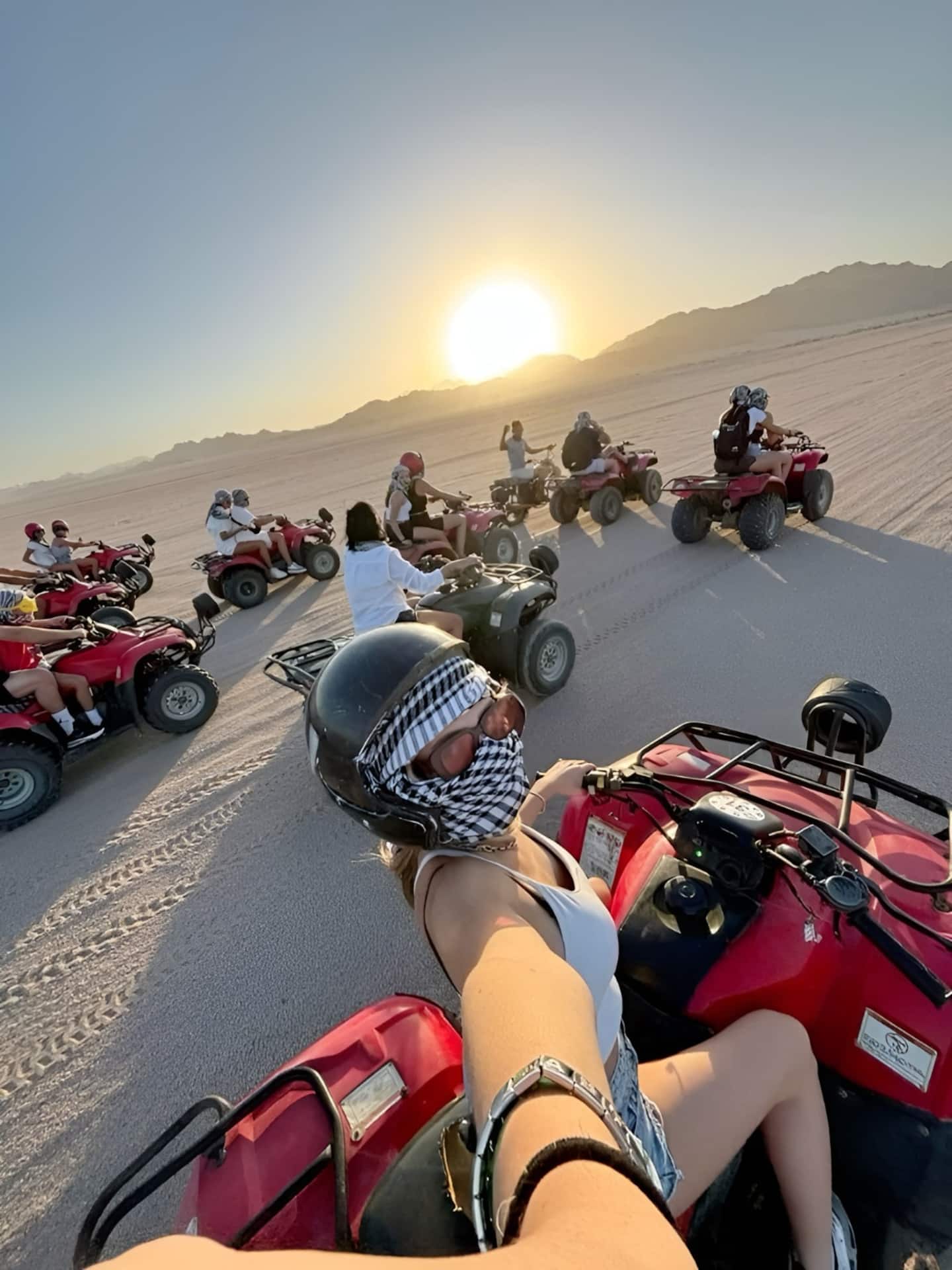 Guests riding quad bikes together at sunset