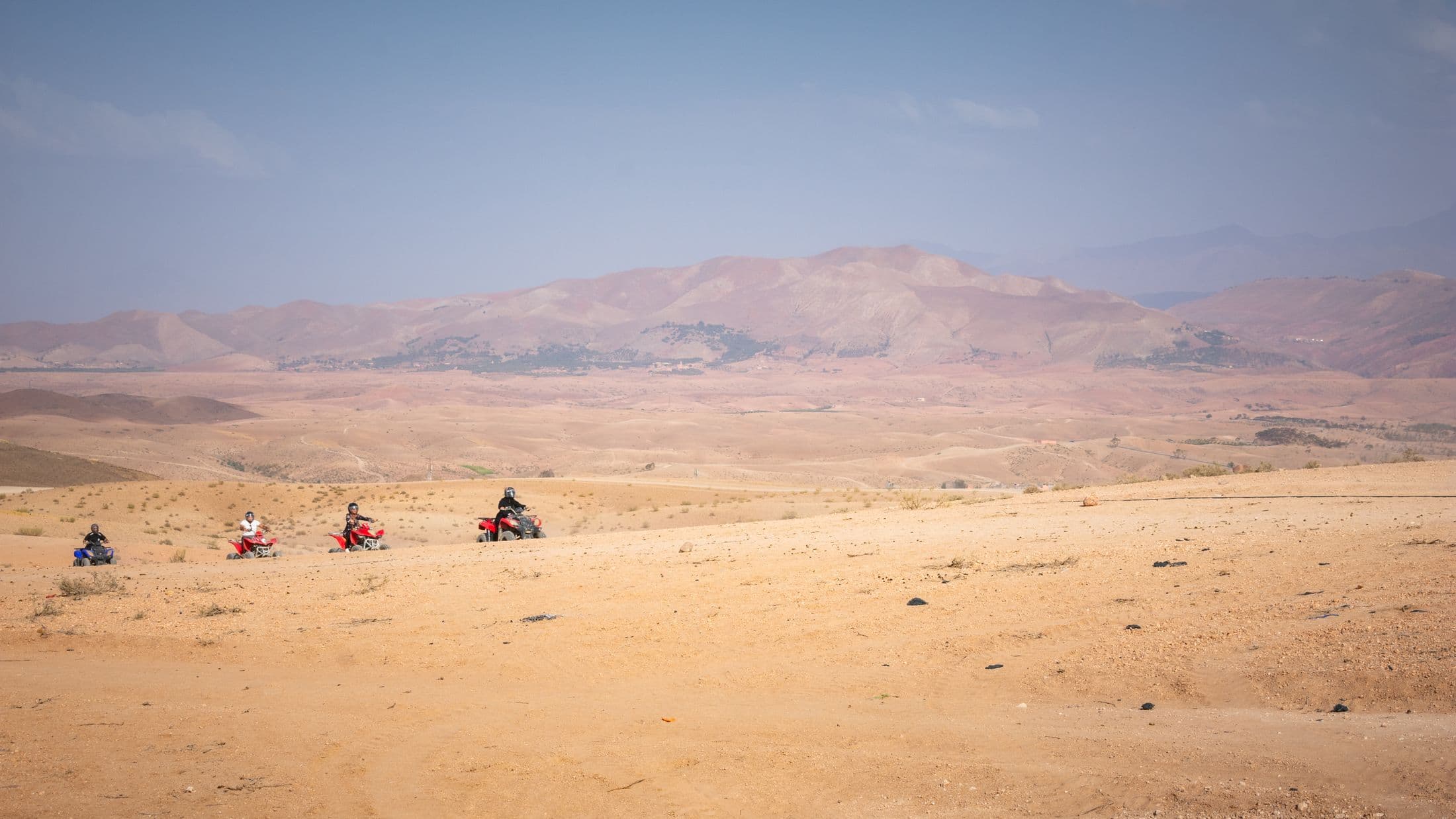Quad riders crossing the rocky Agafay landscape