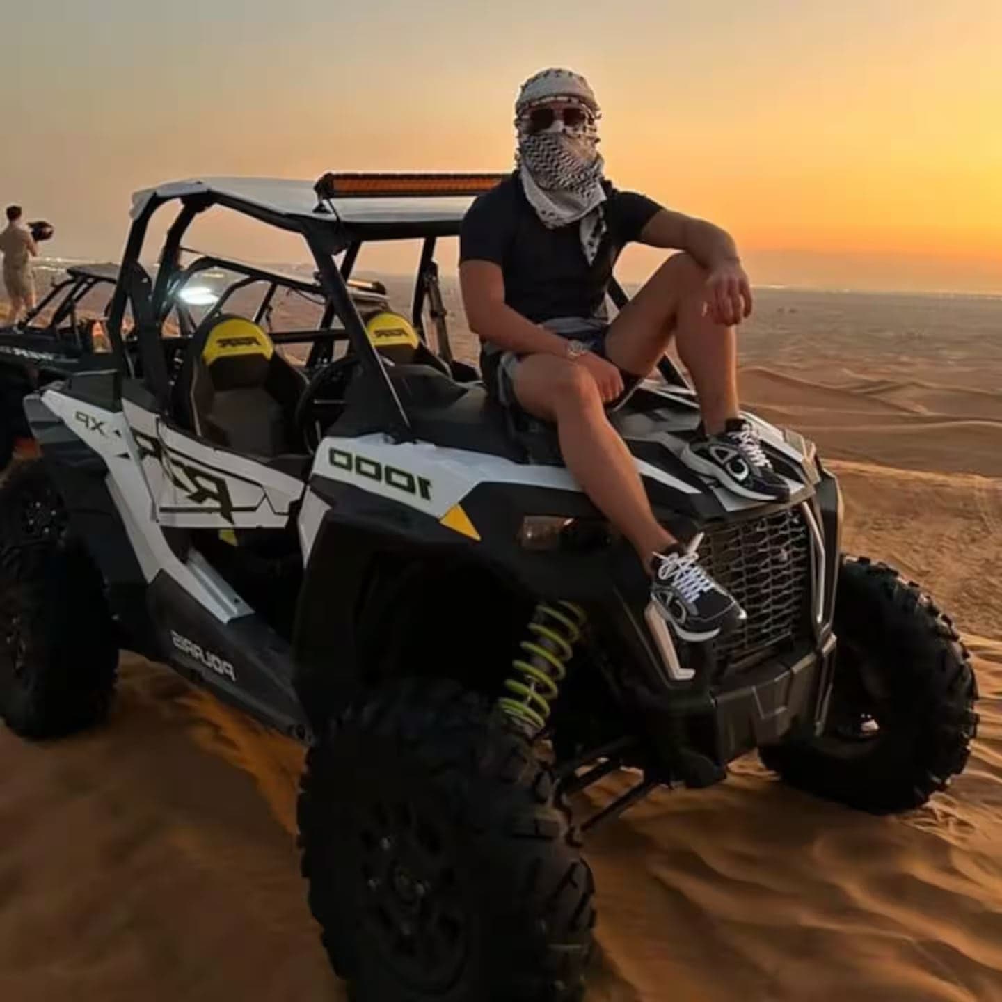 Guest seated on an off-road buggy at sunset